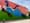Photo of a huge, colorful outdoor mural depicting a woman lying in the grass surrounded by daisies. 